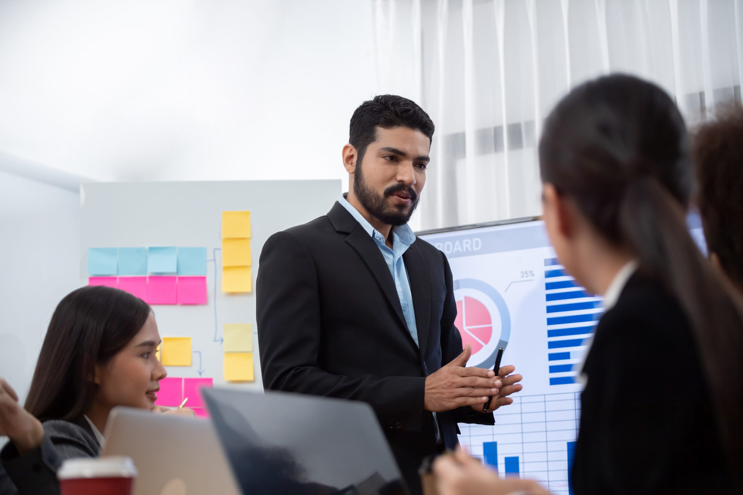 Businessman presenting data analysis dashboard on TV at meeting room. Concord Businessman presenting data analysis dashboard display on TV screen in modern meeting for marketing strategy. Business presentation with group of business people in conference room. Concord